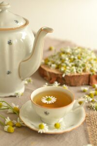 Eine Tasse Tee, die mit Blümchen beschmückt ist.